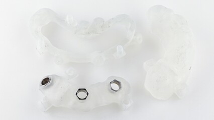 surgical dental template of three parts for the installation of three implants on a white background