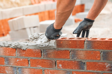Mason Laying Bricks for Wall Construction at a Building Site During Daylight Hours