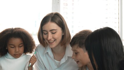 Fototapeta premium Happy diverse student and smart teacher drawing and coloring by using marker at drawing book. Multicultural smart learner using drawing book while talking to skilled caucasian instructor. Erudition.