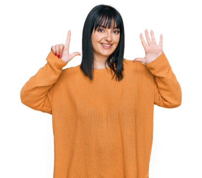 Young hispanic woman wearing casual clothes showing and pointing up with fingers number seven while smiling confident and happy.