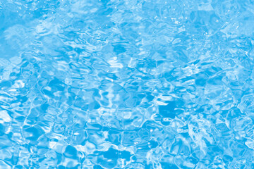 Blue water with ripples on the surface. Defocus blurred transparent blue colored clear calm water surface texture with splashes and bubbles. Water waves with shining pattern texture background.
