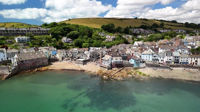 Drone footage of the coastal Kingsand village with green hills in the background in Cornwall, UK