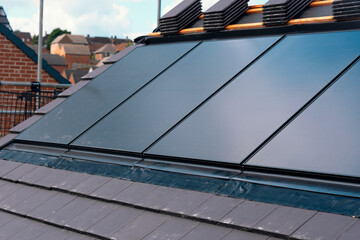 Solar Panels Installed on Modern Rooftop in an Urban Neighborhood During Daylight Hours