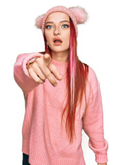 Young caucasian woman wearing casual clothes and wool cap pointing displeased and frustrated to the camera, angry and furious with you