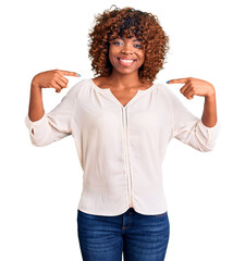 Young african american woman wearing casual clothes looking confident with smile on face, pointing oneself with fingers proud and happy.