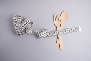 Spoon, fork and tape measure for food clock, healthy eating and diet concept. Healthy lifestyle and weight loss concept. Empty space for text 