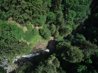 Flying with a drone in the mountains, taking pictures of fir trees, Maria (Mary) river and Marii waterfall in the Retezat Mountains in Uricani, Hunedoara Romania
