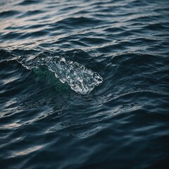 Obraz premium Soft ocean waves lapping at the shore of a secluded beach, with the fading sunlight creating a peaceful and warm ambiance