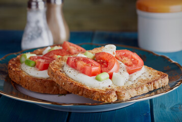 Cheese on toast with tomato and spring onion.