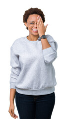 Young beautiful african american woman wearing glasses over isolated background covering one eye with hand with confident smile on face and surprise emotion.