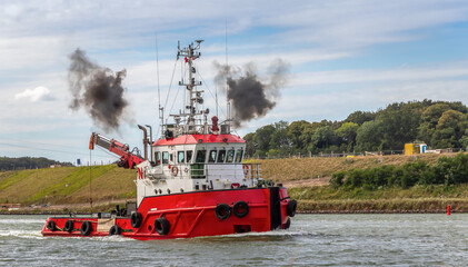 Roter Schlepper auf dem NOK mit qualmenden Auspuffrohren