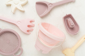Cute toys for playing with sand on concrete background, top view