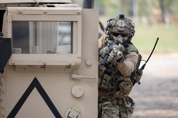 Soldier  in camouflage military uniforms in shooting position  on the side armored fighting car