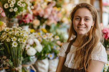 Naklejka premium smiling florist young woman working in florist shop, looking at camera