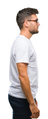 Fototapeta premium Young handsome man wearing glasses over isolated background looking to side, relax profile pose with natural face with confident smile.