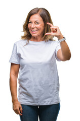 Fototapeta premium Middle age senior hispanic woman over isolated background smiling and confident gesturing with hand doing size sign with fingers while looking and the camera. Measure concept.