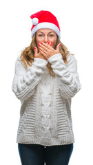 Middle age senior hispanic woman wearing christmas hat over isolated background shocked covering mouth with hands for mistake. Secret concept.