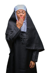 Middle age senior christian catholic nun woman over isolated background bored yawning tired...