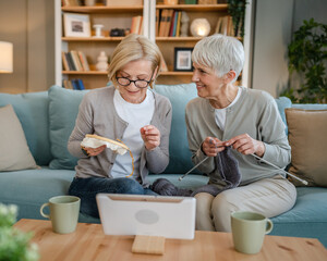 two women senior mature knitting and embroidery during leisure time