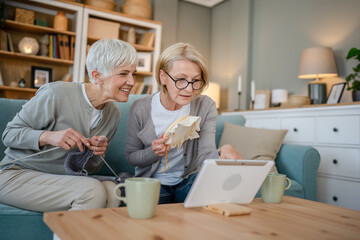 two women senior mature knitting and embroidery during leisure time