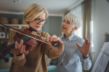 Private music teacher give violin lesson mature senior woman at home