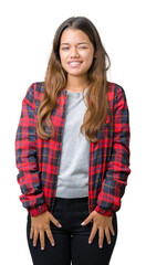 Young beautiful brunette woman wearing a jacket over isolated background winking looking at the...