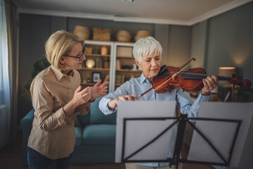 Private music teacher give violin lesson mature senior woman at home