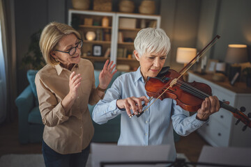 Private music teacher give violin lesson mature senior woman at home