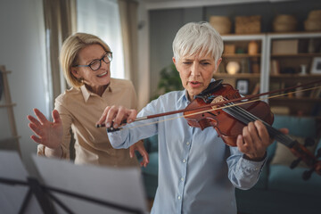 Private music teacher give violin lesson mature senior woman at home