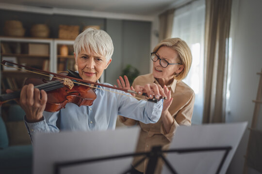 Private music teacher give violin lesson mature senior woman at home