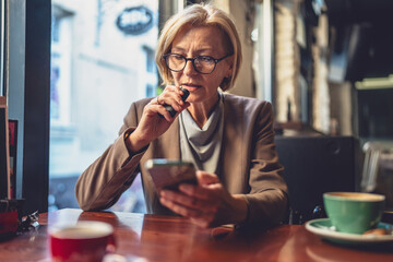 One mature woman caucasian blonde female use mobile phone smartphone