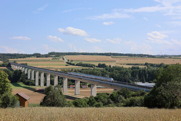 Fototapeta premium Auf der Schnellfahrstrecke Mannheim-Stuttgart überquert ein rasender Intercity die Enztalbrücke bei Vahingen an der Enz.