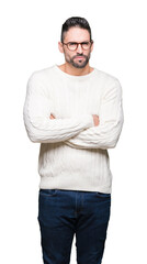 Young handsome man wearing glasses over isolated background skeptic and nervous, disapproving expression on face with crossed arms. Negative person.