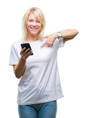 Fototapeta premium Young beautiful blonde woman using smartphone over isolated background with surprise face pointing finger to himself