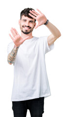 Young handsome man wearing white t-shirt over isolated background Smiling doing frame using hands palms and fingers, camera perspective