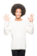 Young african american man with afro hair wearing winter sweater showing and pointing up with fingers number nine while smiling confident and happy.