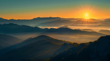 Fototapeta premium A scenic sunrise over rolling mountain peaks with mist and fog in the valleys.