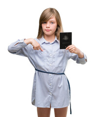 Fototapeta premium Young blonde toddler holding australian passport with surprise face pointing finger to himself