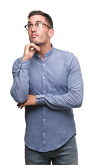 Fototapeta premium Handsome young elegant man wearing glasses with hand on chin thinking about question, pensive expression. Smiling with thoughtful face. Doubt concept.