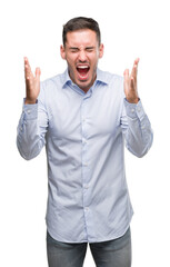 Handsome young businessman celebrating mad and crazy for success with arms raised and closed eyes screaming excited. Winner concept