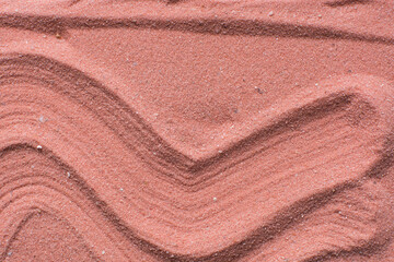 Lines drawn in coral sand background, beautiful sand texture, overhead view of brick orange sand, zen pattern drawn in the sand, Top view of fine grain texture