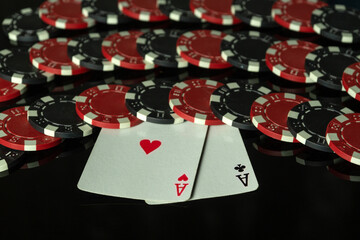 Playing cards two aces and chips on a black table in a poker club. A winning combination of one pair in a casino game. A lucky win