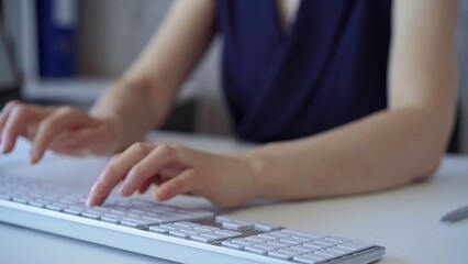 Businesswoman with dark blue blues blues is working on a computer keyboard in the office. Business concept