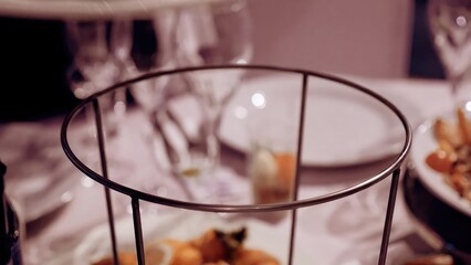 An elegant dining table set with glassware and gourmet dishes in a cozy restaurant at night