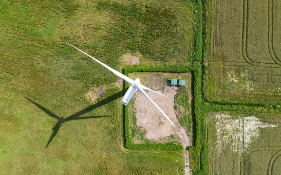 top down birds eye aerial view of a wind turbine in a small rural wind farm in the English countryside