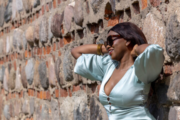 Beautiful young African girl at an old stone wall