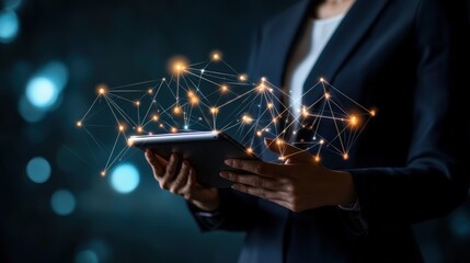 A business professional holding a tablet displaying a network diagram, symbolizing the integration of network technology in modern business.