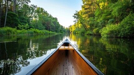 A canoe gliding smoothly down a calm river, surrounded by dense green vegetation, perfect for an outdoor adventure.