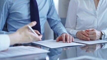 Business people are reviewing a contract papers and discussing the terms of the agreement. Lawyers at work