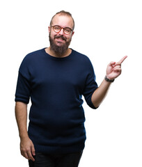 Fototapeta premium Young caucasian hipster man wearing sunglasses over isolated background with a big smile on face, pointing with hand and finger to the side looking at the camera.